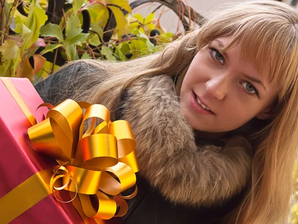 Bir hediye ile genç gülümseyen kız — Stok fotoğraf