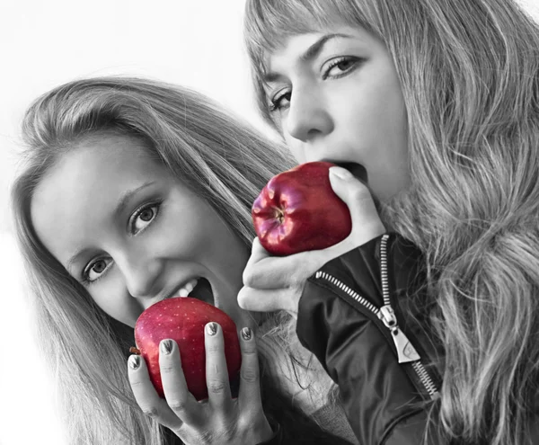 Dos chicas jóvenes atractivas comiendo manzanas — Foto de Stock