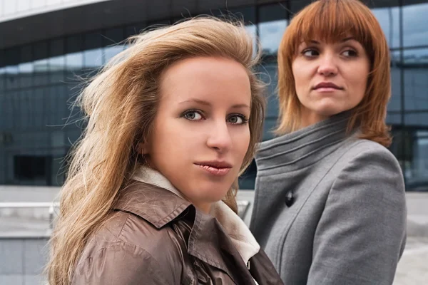 Två vackra flickor nära företag byggnad — Stockfoto