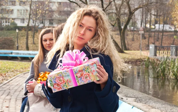 Vacker ung blond flicka med en present — Stockfoto