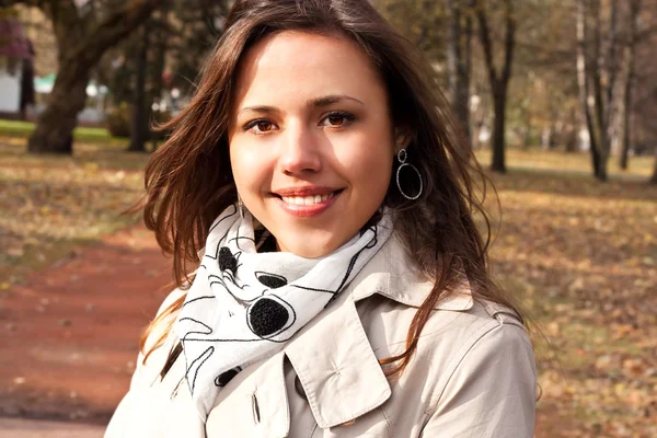 Roztomilý usměvavá mladá brunetka v parku — Stock fotografie