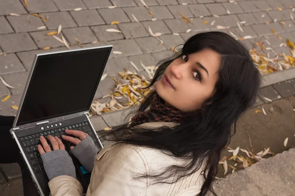Atractiva joven sosteniendo un ordenador portátil — Foto de Stock
