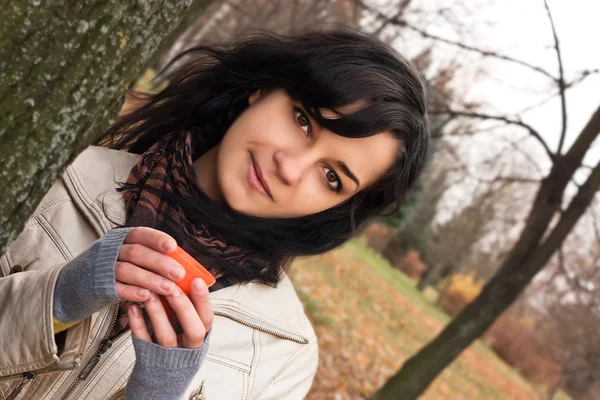 Sensuele jonge dame met een kopje thee in het park — Stockfoto