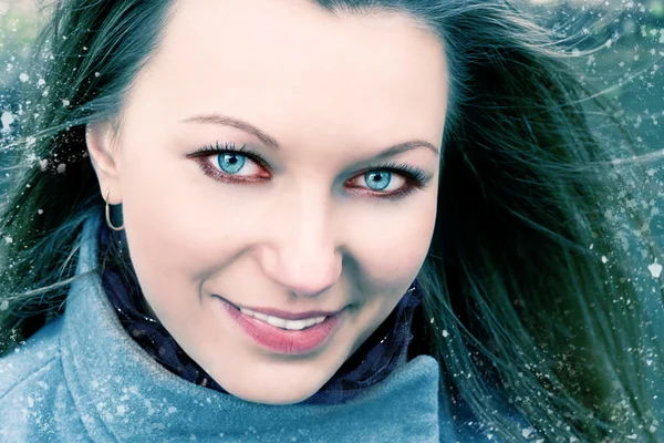 Mooie lachende brunette vrouw in sneeuw — Stockfoto