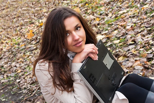 Sensual young brunette girl holding a laptop — Stock Photo, Image