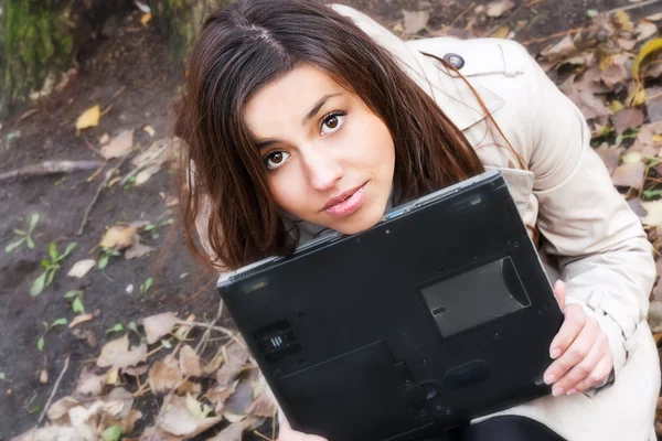 Chica bastante joven sosteniendo un ordenador portátil — Foto de Stock