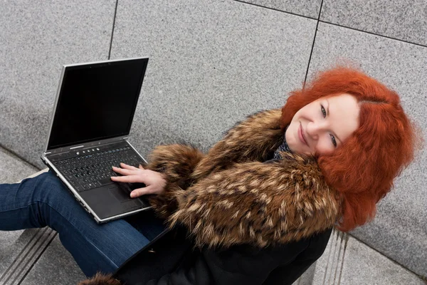 Vacker ung flicka med en bärbar dator — Stockfoto