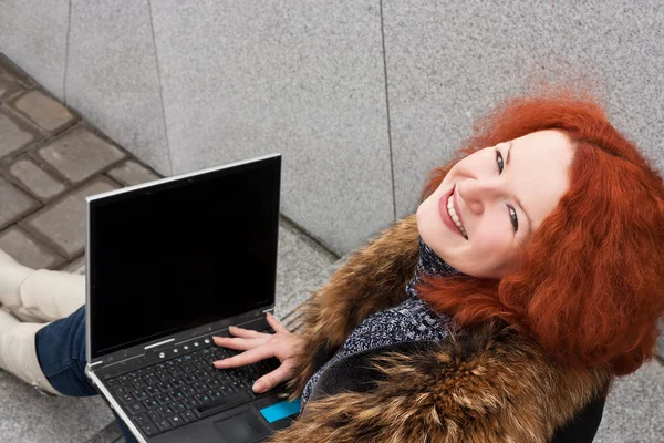 小姑娘微笑着用一台笔记本电脑 — 图库照片