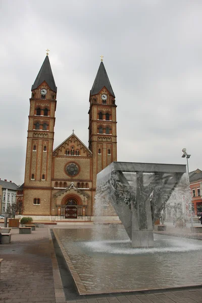 stock image Roman catholic church and fountain on an area before him.