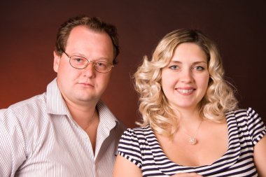 Photo of man and his pregnant wife in a studio