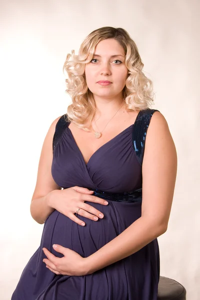 Koyu mavi bir elbise içinde bekleyen anne fotoğrafı — Stok fotoğraf
