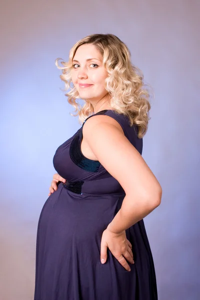 濃い青のドレスに妊娠中の母親の写真 — ストック写真