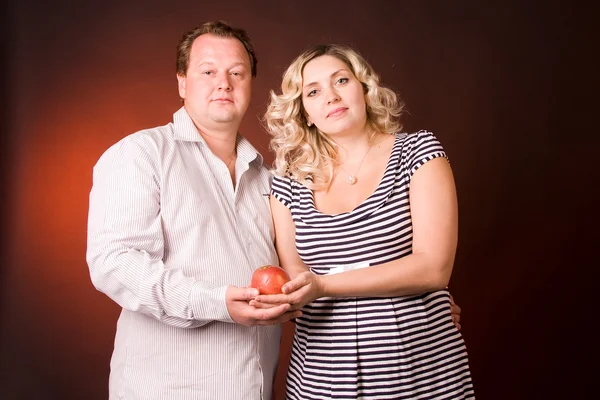 Stüdyoda meyve taşıyan bir adamla hamile karısının fotoğrafı. — Stok fotoğraf