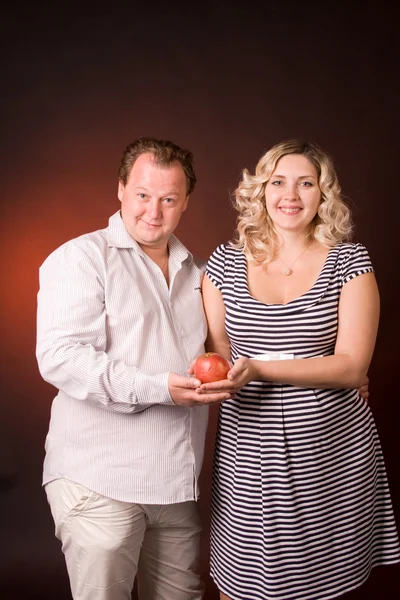 Photo de l'homme et sa femme enceinte dans un studio avec des fruits — Photo
