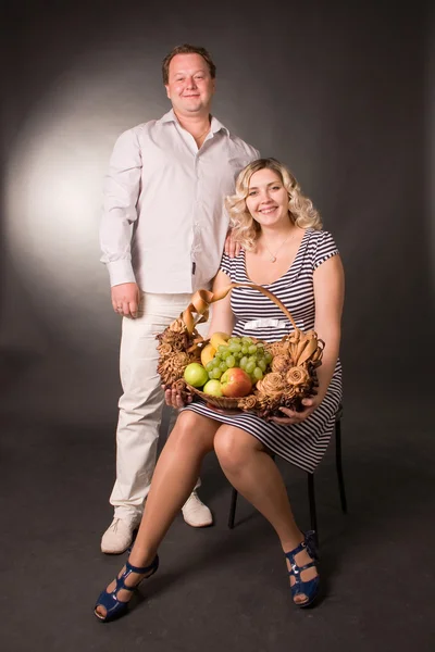 Zdjęcie młodych par małżeńskich w studio z koszem owoców — Zdjęcie stockowe