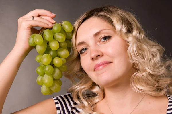 stock image Portrait of beautiful young woman of blonde with the cluster of green vine