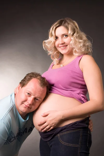 Мужчина слушает чрево беременной жены — стоковое фото