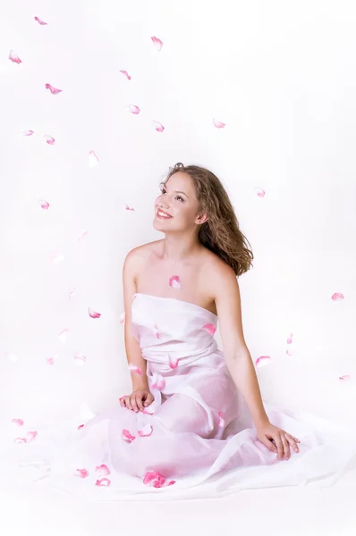 Hermosa joven con pétalos de flor de rosa aislados en blanco — Foto de Stock