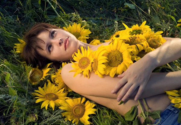 Mooie vrouw en zonnebloemen — Stockfoto