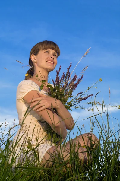 Mujer con flores en pradera verde — Foto de Stock