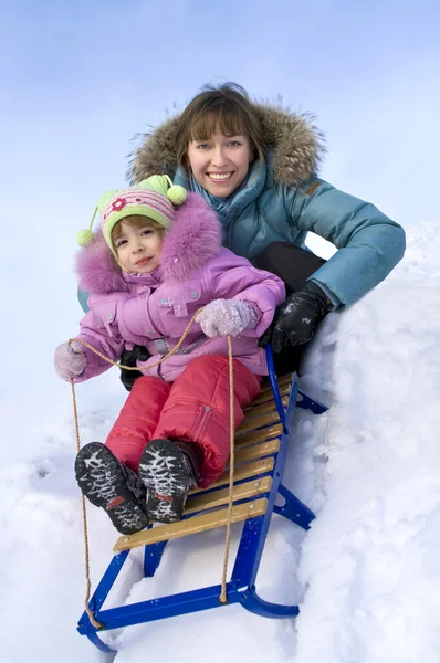 Anne ve küçük kızı karda kayan — Stok fotoğraf