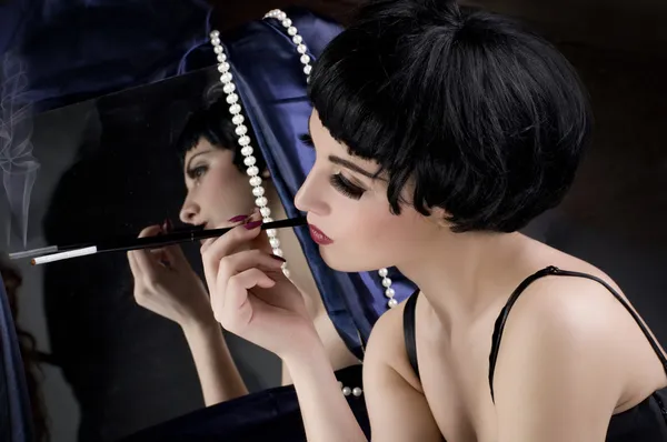 鏡の前にタバコと美しいブルネットの少女 — ストック写真