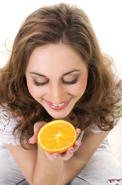 Hübsche junge Frau isst eine Orange — Stockfoto
