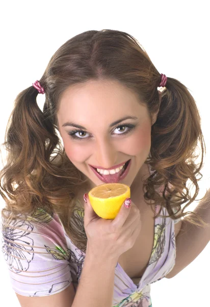 Une jolie jeune femme mangeant un citron sur fond blanc — Photo