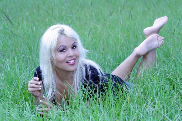 Sexig blondin liggande på en gräsbevuxen område (6) — Stockfoto