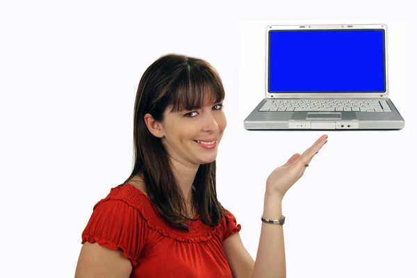 可爱的年轻黑发的女主人带着迷人的微笑 看起来在查看器中直接指向一台便携式计算机显示一个空白的蓝色屏幕的同时 — 图库照片