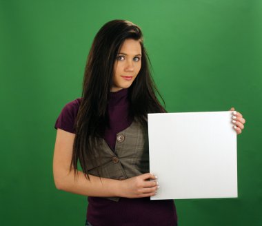 A lovely teenage girl with black hair holds a small blank white card. clipart