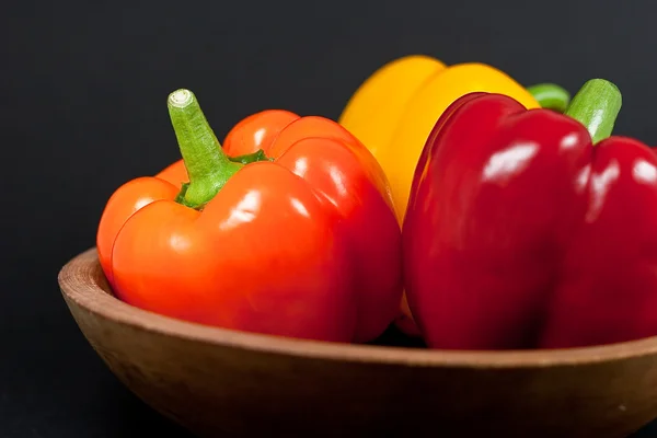 Three Bell Peppers in a wood bowl — Stock Photo, Image