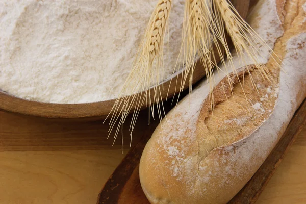 Pan crujiente de baguette con tazón de madera lleno de harina — Foto de Stock