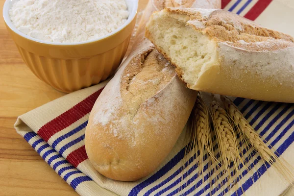 Vynikající kůrkou bageta chleba na červený ručník bílé a modré — Stock fotografie