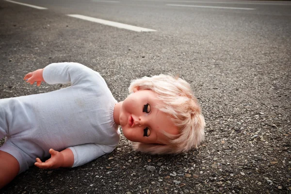 Doll leave on a highway lane — Stock Photo, Image