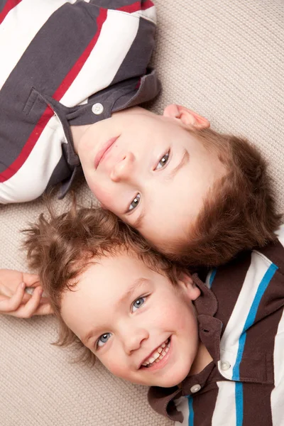 Dwóch braci szczęśliwy leżeć na kanapie — Zdjęcie stockowe