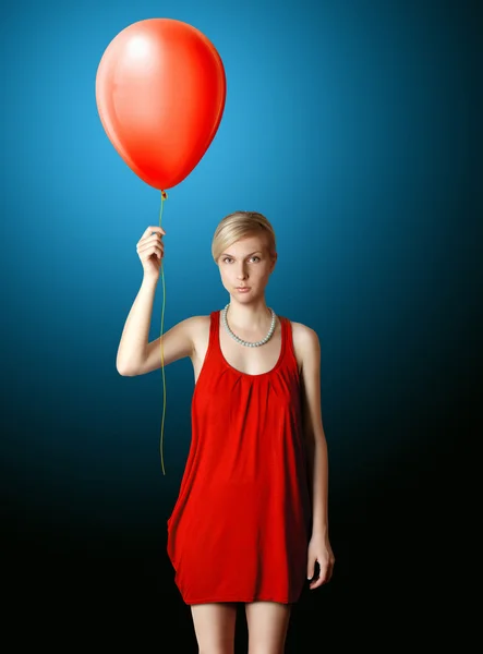 Blondine im roten Kleid mit dem roten Ballon — Stockfoto