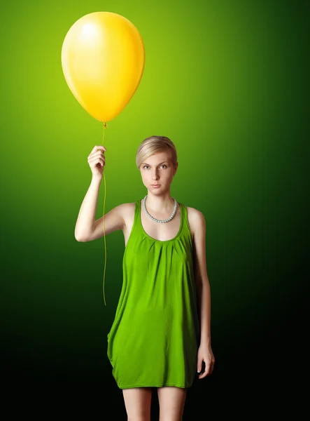 Blondýna v zelených šatech s žlutým balónem — Stock fotografie