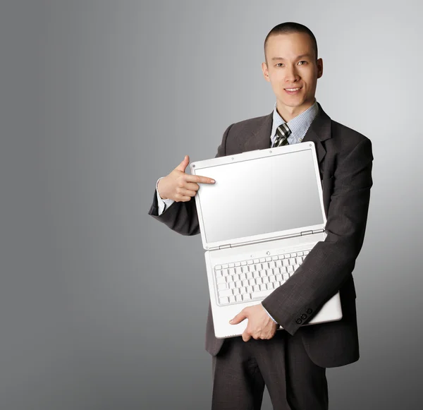 Empresário com laptop aberto mostra algo — Fotografia de Stock