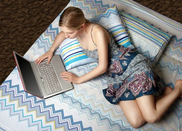 便携式计算机放在床上的女孩 — 图库照片