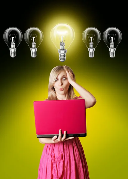 Blondine im rosa Kleid mit Laptop und Glühbirne — Stockfoto