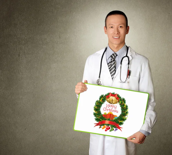 メリー クリスマス画像と空のボードを持つ医師 — ストック写真