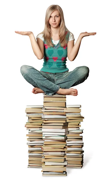 Frau in Lotuspose balanciert auf Bücherstapel — Stockfoto