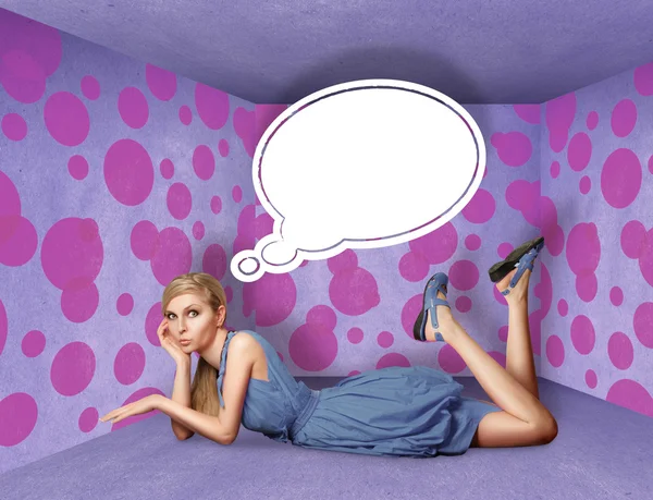 Surprised blonde in blue dress with thought bubble Stock Photo