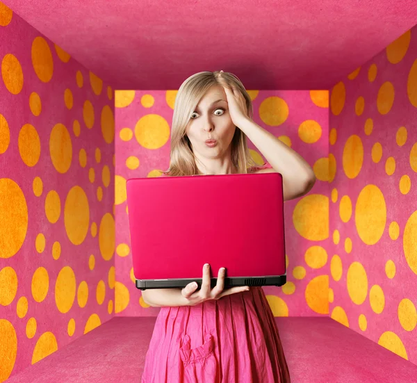 Blondýnka v růžových šatech s notebookem — Stock fotografie