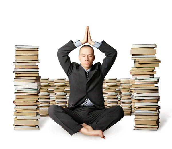 Empresario en pose de loto con muchos libros cerca —  Fotos de Stock