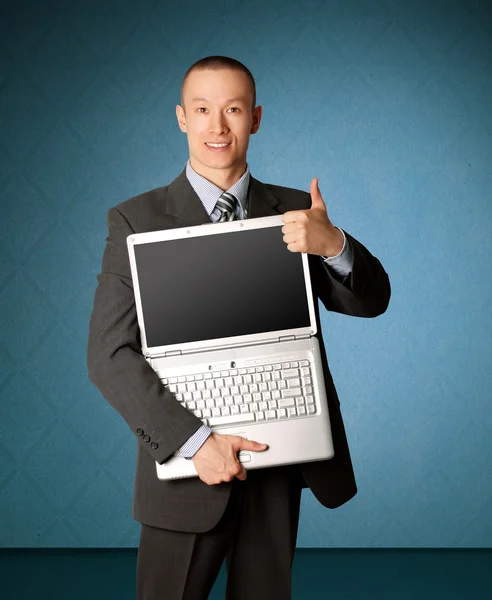 開いているノート パソコンで高価なスーツのビジネスマンはよく焼けているを示しています — ストック写真