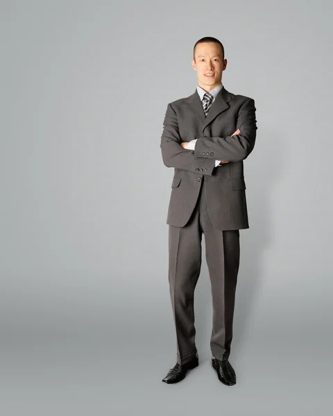 Sonriente hombre de negocios de pie en traje —  Fotos de Stock
