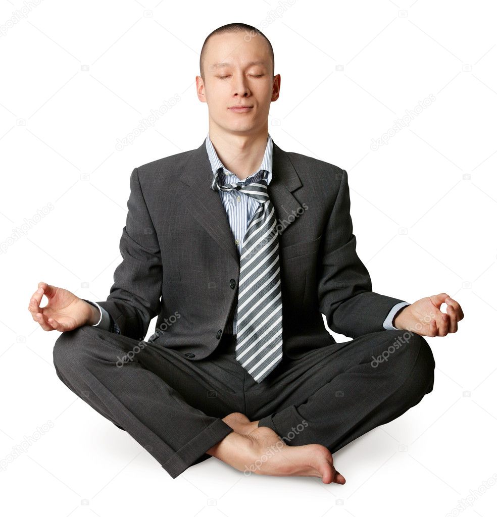 Businessman in lotus pose meditating at the office