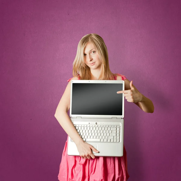 Femaile 女人在粉红色与笔记本电脑打开显示的东西 — 图库照片